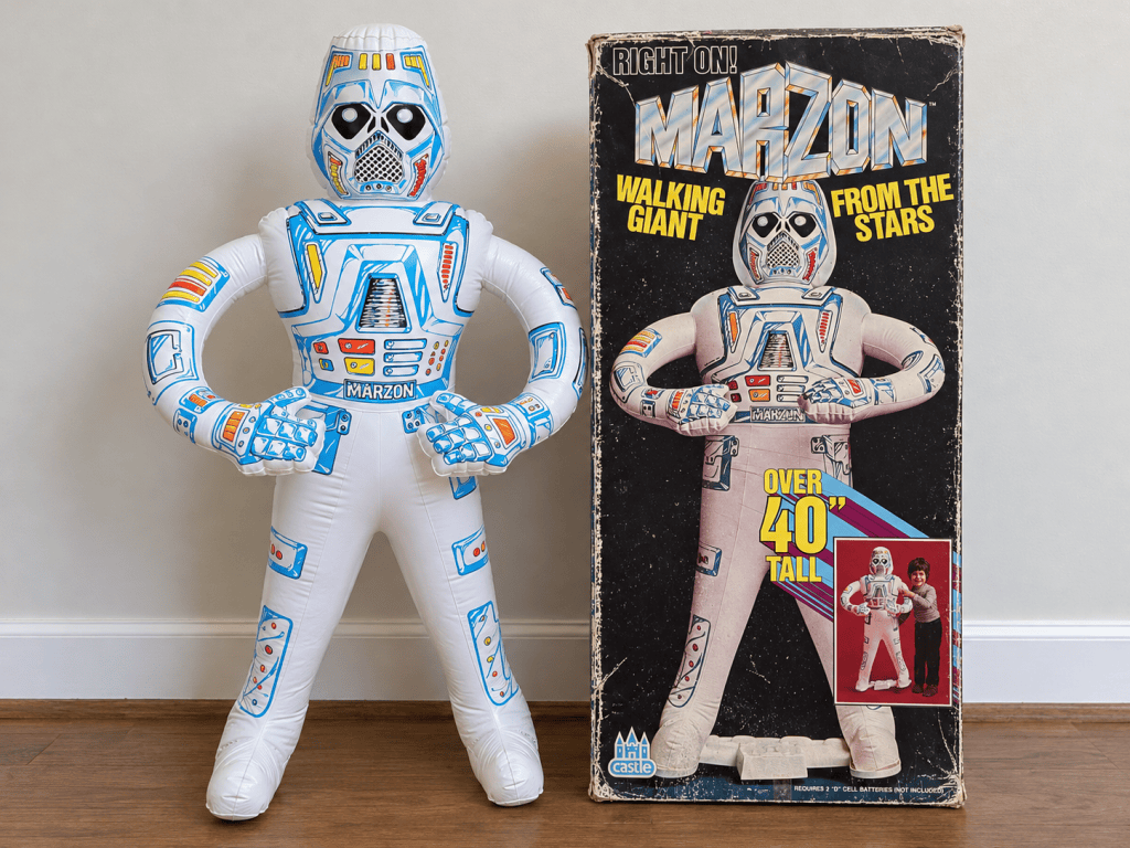 Inflatable toy figure named Marzon, resembling a robot with a blue and white design, displayed next to its box packaging with an illustration of the toy and height information.